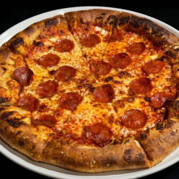 A whole pepperoni pizza with melted cheese and a golden crust, sliced and ready to eat.